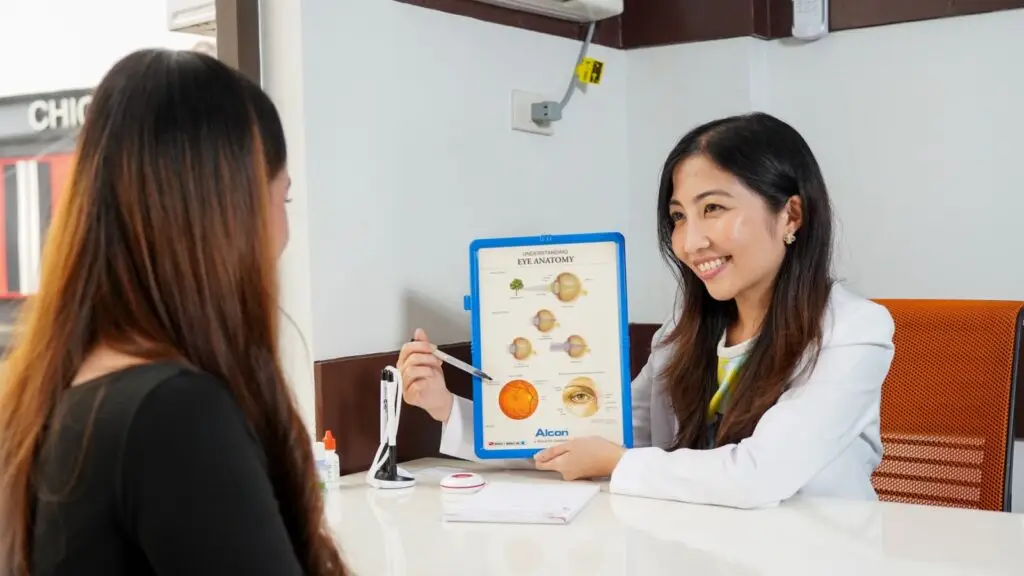 Doctor showing ear anatomy chart to patient in clinic.